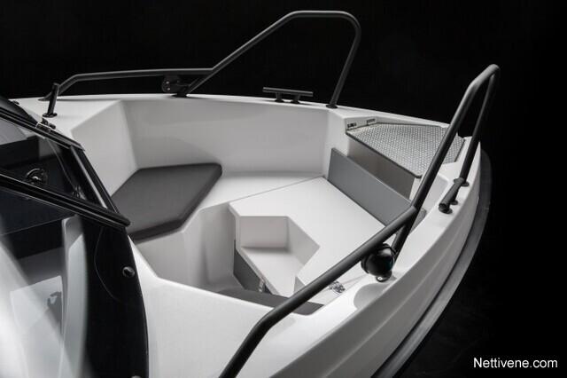 Interior of a sleek, modern boat featuring a white seating area, black accents, and a spacious layout. Nettivene.com.
